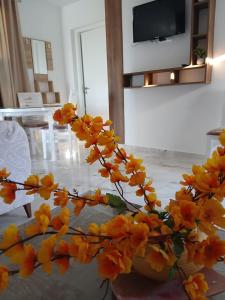 a vase filled with yellow flowers on a table at Appartement chic et luxueux in Rejiche