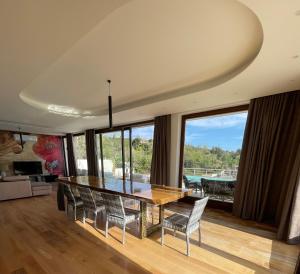 ein Esszimmer mit Tisch und Stühlen und einem großen Fenster in der Unterkunft Villa Ormalute in Pozzuoli