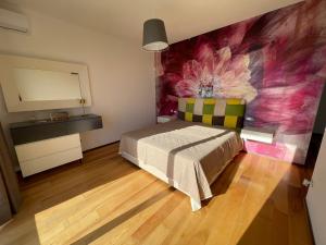 ein Schlafzimmer mit einem Bett und einem Gemälde an der Wand in der Unterkunft Villa Ormalute in Pozzuoli + 65 Fotos
