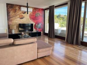 ein Wohnzimmer mit Sofa und Fernseher in der Unterkunft Villa Ormalute in Pozzuoli