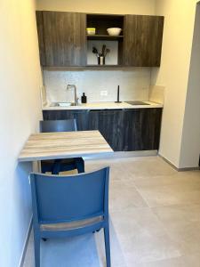 a kitchen with a wooden table and blue chairs at Anastasi Residence in Cervia