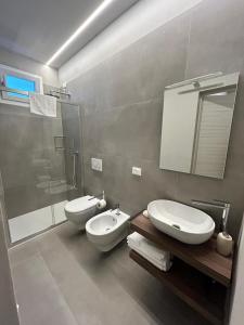 a bathroom with two toilets and a shower and a sink at Anastasi Residence in Cervia
