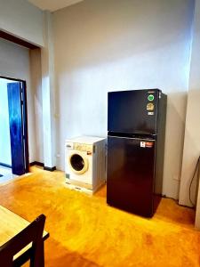 a black refrigerator in a room with a microwave at Amazing beach apartment Phuket in Phuket