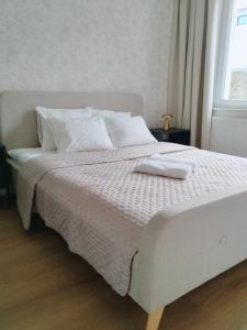 a white bed with a white blanket and pillows at Apartament MiA in Mrągowo