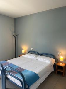 a bed in a bedroom with two lamps on two tables at Ostello Del Porto in Lovere