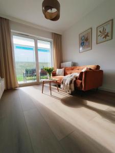 a living room with a couch and a table at Apartament MiA in Mrągowo