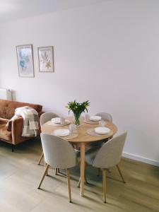 a dining room table with chairs and a table and a couch at Apartament MiA in Mrągowo