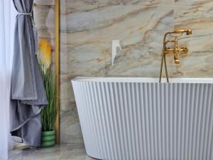 a bath tub in a bathroom with a marble wall at Casa Anitta in Buşteni +63 photos