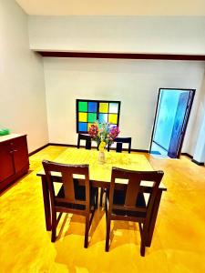 a dining room with a table and chairs with a vase of flowers at Amazing beach apartment Phuket in Phuket