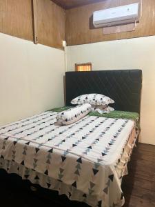 a bedroom with a bed with a black headboard at Tiu Batu Homestay in Bangsal +21 photos