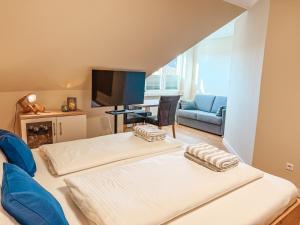 a living room with two beds and a tv at Apartmenthaus Leuchtfeuer in Norderney