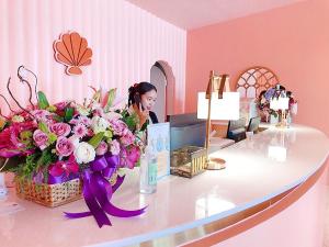 a woman sitting at a reception desk with a bouquet of flowers at 752 Residence Hua Hin in Hua Hin