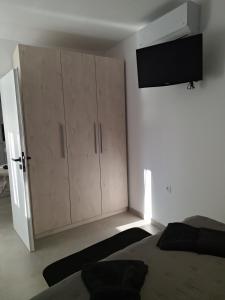 a bedroom with a bed and a large cabinet at Joy's apartment in Markopoulo