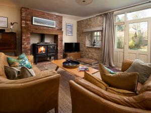 a living room with two couches and a fireplace at The Old Coach House in Alnwick