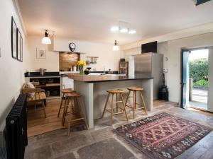 a kitchen with a large island with bar stools at The Old Coach House in Alnwick