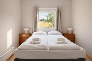 a bedroom with a large white bed with a window at A pearl in Lofoten in Leknes