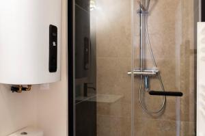 a shower with a glass door next to a toilet at Appartements en centre ville à Châteauroux Indre in Châteauroux +14 photos