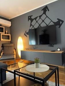 a living room with a table and a tv at Apartman Mali Muk, self check- in in Karlovac
