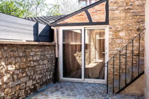 a sliding glass door on a brick wall with a staircase at Appartements en centre ville à Châteauroux Indre in Châteauroux