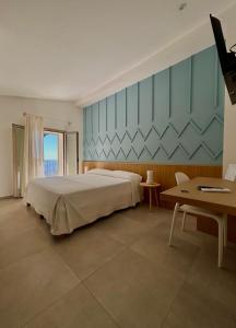 a bedroom with a large bed and a table at Tarsis Guest House in Baunei