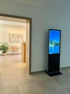 a flat screen tv on a wall in a room at Tarsis Guest House in Baunei