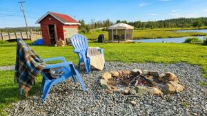 a fire pit with two chairs and a fire place at Sutaz Ocean Side Home in Port Dufferin