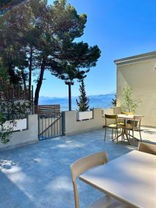 a patio with tables and chairs and a view at Tarsis Guest House in Baunei