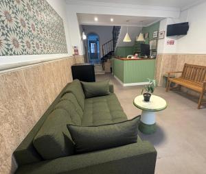 a living room with a green couch and a table at Hostal Paco Marbella in Marbella
