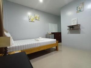 a room with a bed with a white mattress at Grae’s Apartelle in Moalboal