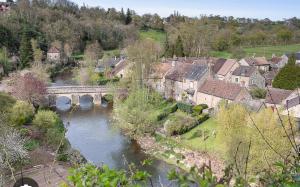 a village with a bridge and a river at Le calme dans 100M2 in Condé-sur-Sarthe