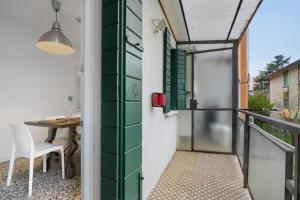 a balcony with a green door and a table at Venezia, 15 minutes from Venice, Parking,Shuttle airport, Train station Miranese in Mestre