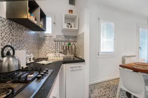 a kitchen with white cabinets and a stove top oven at Venezia, 15 minutes from Venice, Parking,Shuttle airport, Train station Miranese in Mestre +41 photos