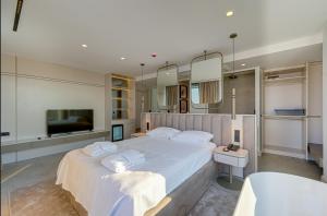 a bedroom with a large white bed and a tub at VENTO MARE Çeşme in Çeşme
