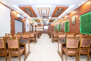 a row of tables and chairs in a restaurant at Mahabhoj Hotel & Restaurant in Mandarmoni +24 photos