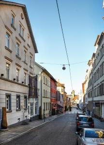 an empty city street with buildings and cars parked at Der Zauberlehrling in Stuttgart