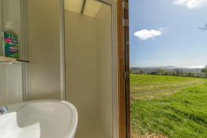 a bathroom with a sink and a view of a field at Boscoppa Farm-Emperor Tent 1 in St Austell