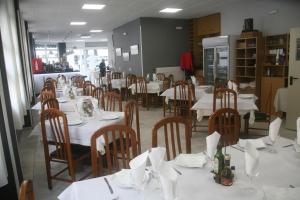 a dining room with tables and chairs with white table cloth at Hostal El Altet in El Alted