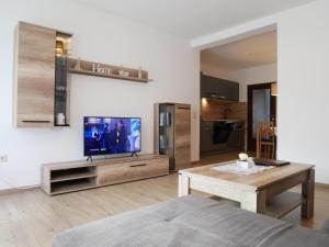 a living room with a tv and a table at Haus Gertrud in Carolinensiel