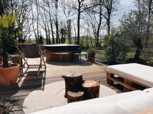 a wooden deck with a hot tub and some trees at Tiny Cabin met airco en privé hottub in Rutten