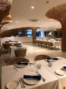 a restaurant with tables and chairs with white tablecloths at Seaside Living Studio Unit in Maribago