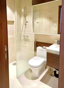 a bathroom with a toilet and a shower and a sink at Seaside Living Studio Unit in Maribago