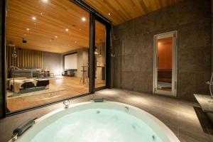 a bath tub in a bathroom with a large window at Zai-On 在恩 in Kutchan +14 photos