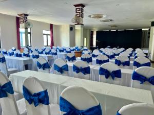 a room with a bunch of chairs and tables with blue bows at Center Orient Hotel in Danang