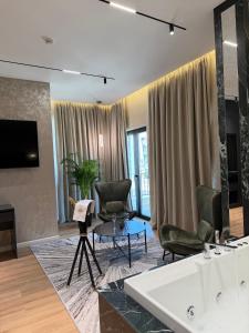 a living room with two chairs and a tv at Hotel Monaco in Kamëz