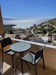 a table and chairs on a balcony with a view of the ocean at Kloen Sunset Villa in Sarandë