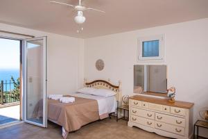a bedroom with a bed and a dresser and a mirror at Scorpina Horizon Villa in Kalamitsi