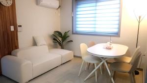a living room with a white couch and a table at Pine-tree stay Mini in Samgong