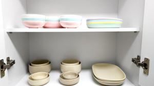 a bathroom with a shelf with three bowls and a toilet at Pine-tree stay Mini in Samgong