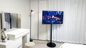 a living room with a tv on a pole in a room at Pine-tree stay Mini in Samgong