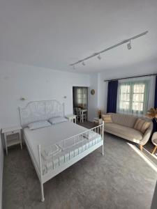 a white bedroom with a bed and a couch at Sun & Moon Studio Afitos in Afitos